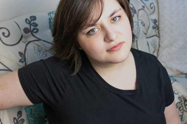 jovem mulher confiante com cabelo curto em seus 20 anos sentada na cadeira
 - Foto, Imagem
