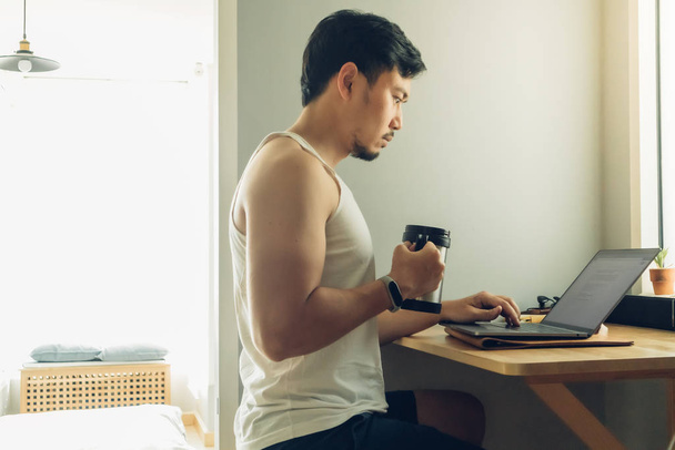 Man is working on his laptop in his house. - 写真・画像