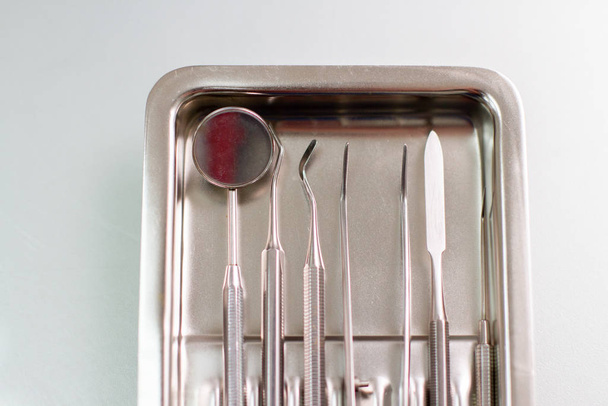 Zestaw profesjonalnych narzędzi dentystycznych. Narzędzia lekarskie w metalowej tacy - Zdjęcie, obraz