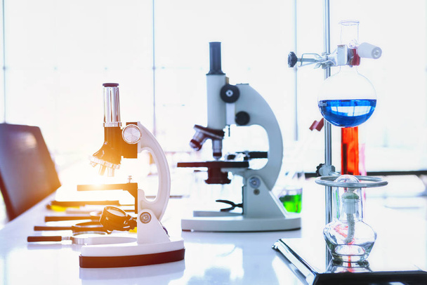Microscope and test tubes with lab glassware in laboratory backg - Φωτογραφία, εικόνα