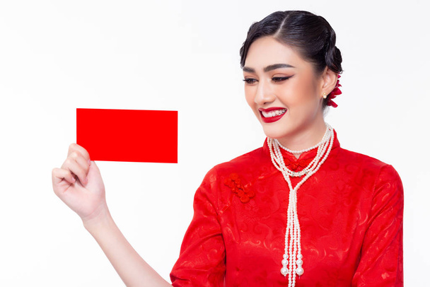У китайському новому році красива молода китайка показує червоний конверт. Приваблива красива азійська дівчина носить китайську сукню або чонгсам. Красива жінка стає щасливою, усміхаючись, коли отримує червоний конверт. - Фото, зображення
