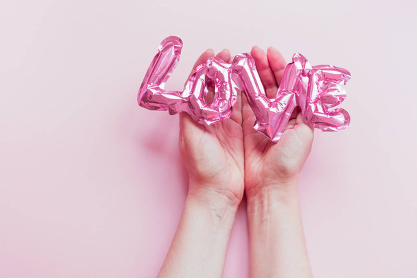 Liebe. aufblasbarer rosa Ballon in den Händen - Foto, Bild