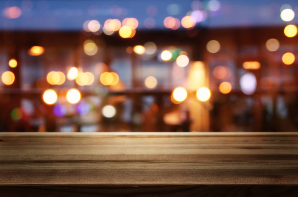 background Image of wooden table in front of abstract blurred restaurant lights - Φωτογραφία, εικόνα