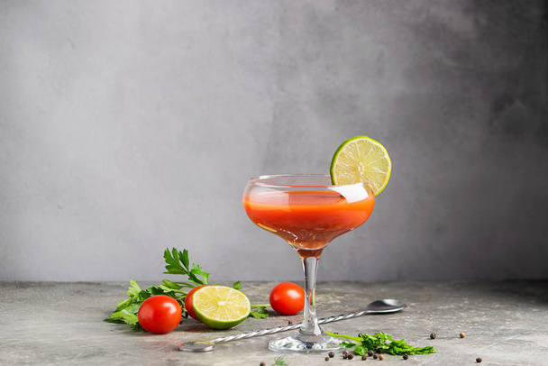 Bloody mary tomato juice cocktail and ingredients tomato, lime, celery, parsley. Strong drinks in elegant glass glasses - 写真・画像