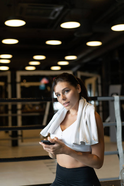 Chica de mensajes de texto mientras toma un descanso en un gimnasio. Lee un mensaje
 - Foto, Imagen