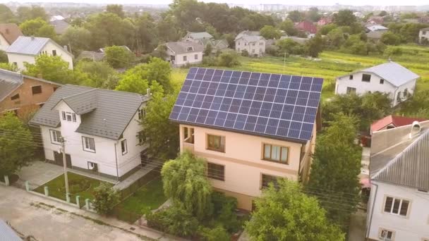 Çatıda mavi parlak güneş enerjili voltaik panelleri olan yeni, modern ev kulübesinin havadan görünüşü. Yenilenebilir ekolojik yeşil enerji üretim kavramı. - Video, Çekim