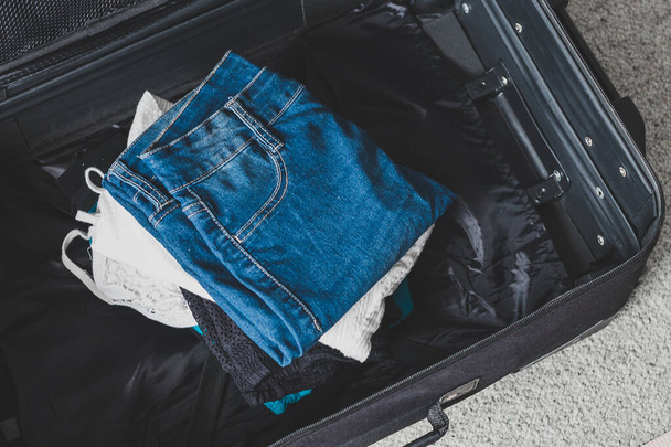 packing for a holiday concept, luggage with pile of clothes insi - Fotoğraf, Görsel