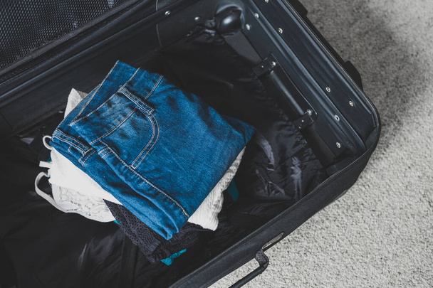 Verpackung für ein Urlaubskonzept, Gepäck mit Kleiderstapeln insi - Foto, Bild
