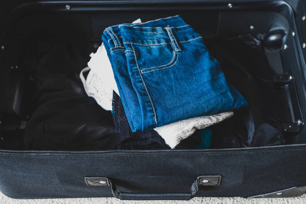 packing for a holiday concept, luggage with pile of clothes insi - Φωτογραφία, εικόνα
