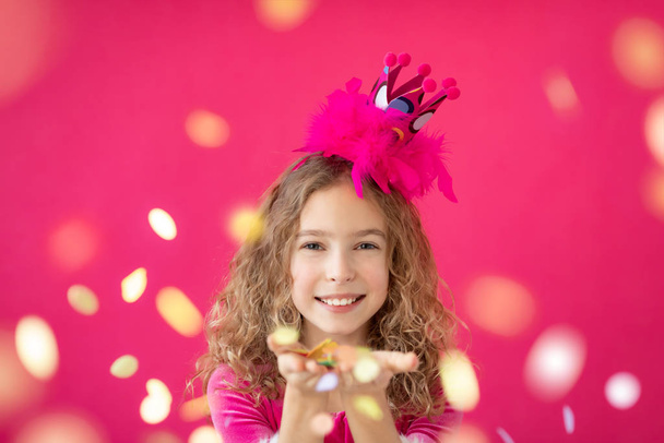 Fancy girl blowing confetti against pink bakground - Foto, imagen