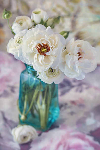 Белый ранункул. Прекрасный букет весенних цветов в вазе на столе. Пастельная тональность. - Фото, изображение