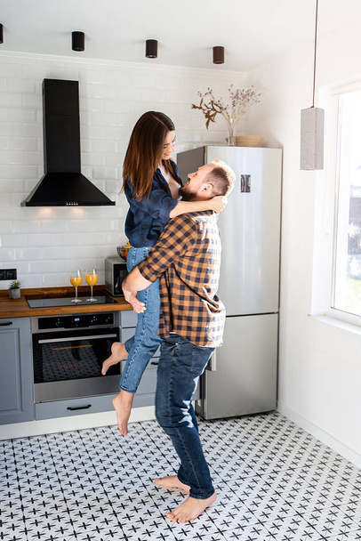 A guy with a girl in casual plaid shirts in the kitchen - Photo, image