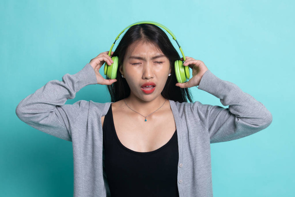 Too loud.  portrait of  young asian woman  holding  headphones a - Foto, Imagem
