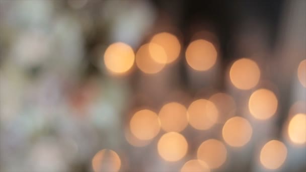 Glare from sparks of candles in the church. The lights flicker in a vintage style, and the flicker of the lights conveys a festive mood. Beautiful radiance for holiday stories. Blurry glare of light. - Footage, Video