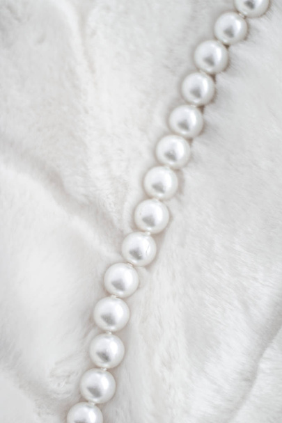 Χειμερινές διακοπές κοσμήματα μόδας, μαργαριτάρι κολιέ σε γούνα backgrou - Φωτογραφία, εικόνα