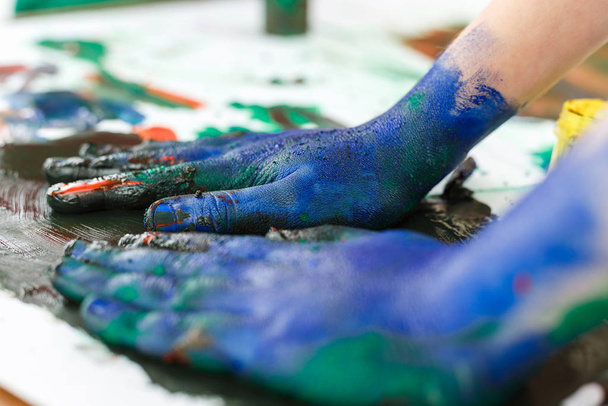 blue painted hands on background of light table - Fotografie, Obrázek