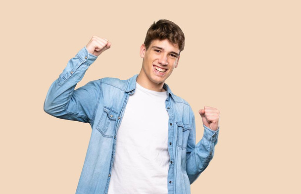 Handsome young man celebrating a victory over isolated background - Photo, image