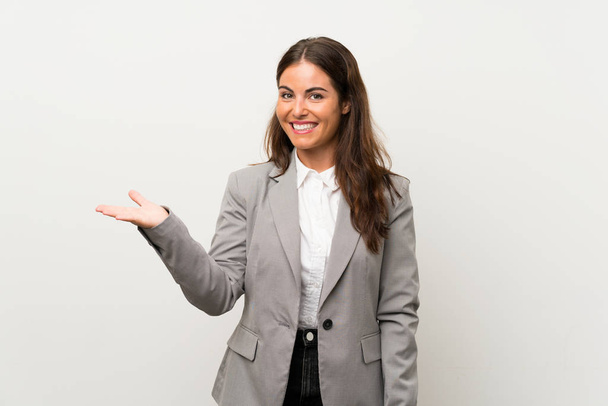 Молодая деловая женщина на изолированном белом фоне с воображаемым копирайтом на ладони
 - Фото, изображение