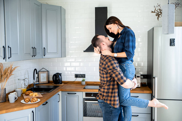 A guy with a girl in casual plaid shirts in the kitchen - Photo, Image