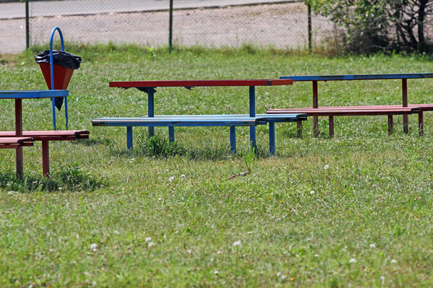 Benches and a trash bin in the grass outside in nature. - Photo, Image