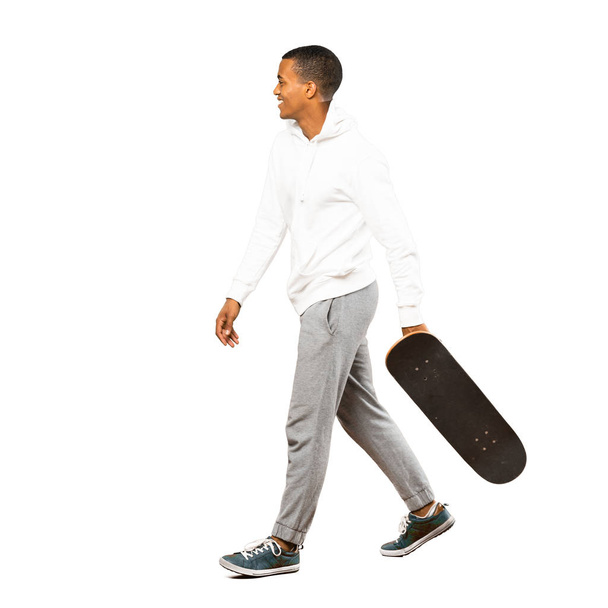 Full-length shot van Afro Amerikaanse skater man over geïsoleerd wit - Foto, afbeelding