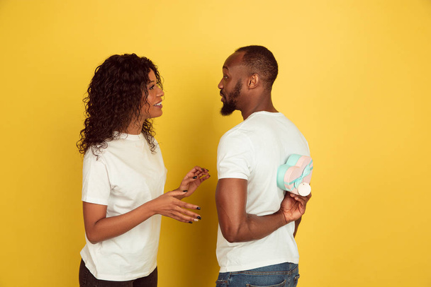 Valentines day celebration, happy african-american couple isolated on yellow background - Photo, image