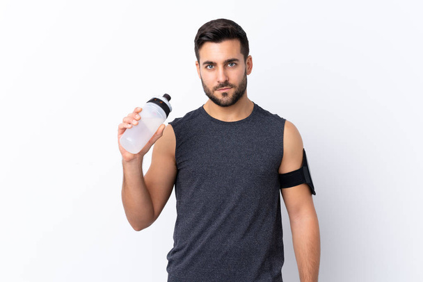 Giovane sport bell'uomo con la barba su sfondo bianco isolato con bottiglia d'acqua sportiva
 - Foto, immagini