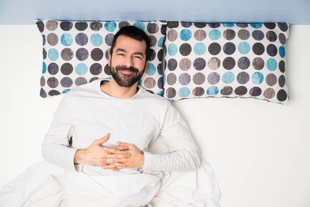 Mann im Bett in der Draufsicht lächelt - Foto, Bild