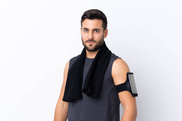 Young sport handsome man with beard over isolated white background with sport towel - Photo, Image