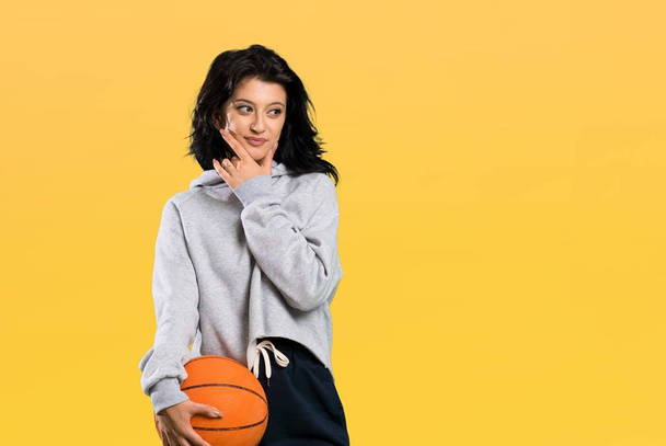 Молодая женщина, играющая в баскетбол, думает об идее на изолированном фоне
 - Фото, изображение