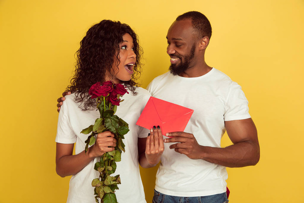 Valentinstag-Feier, glückliches afrikanisch-amerikanisches Paar isoliert auf gelbem Hintergrund - Foto, Bild