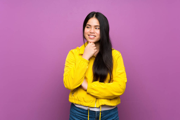Young teenager Asian girl over isolated purple background looking to the side - Φωτογραφία, εικόνα