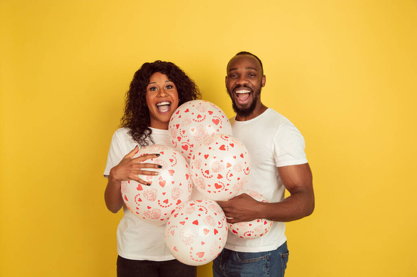 Valentines day celebration, happy african-american couple isolated on yellow background - Valokuva, kuva