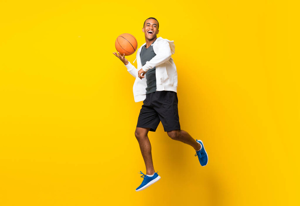 Afro American basketball player man over isolated yellow backgro - Fotografie, Obrázek