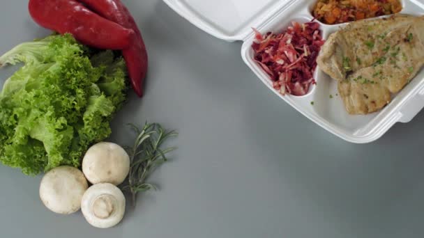 Verpackung von Lebensmitteln zum Mitnehmen in Styroporbox. frische Lieferpackung mit Hühnerbrust, Reis mit Gemüse und Salat - Filmmaterial, Video