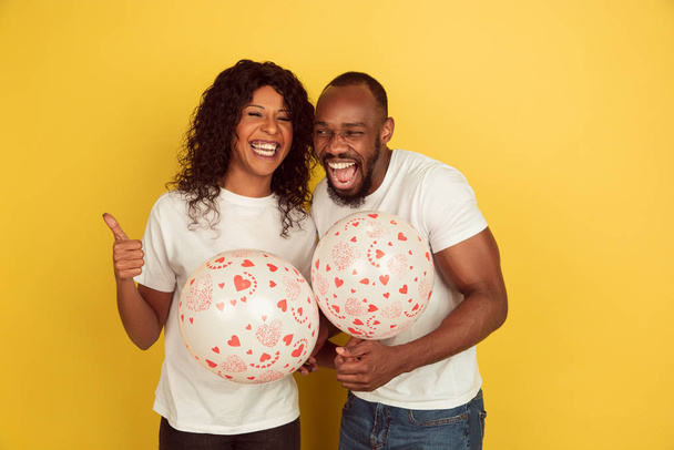 Valentines day celebration, happy african-american couple isolated on yellow background - Foto, Imagen