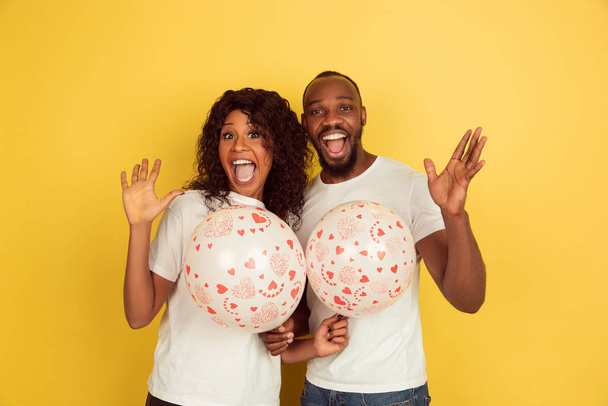 Valentines day celebration, happy african-american couple isolated on yellow background - Fotoğraf, Görsel