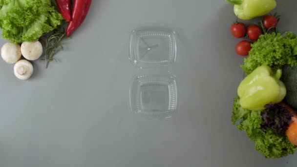 Συσκευασία takeaway τροφίμων σε πλαστικό κουτί. Φρέσκο γεύμα πακέτο παράδοσης με σαλάτα - Πλάνα, βίντεο