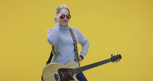 Female guitarist putting on sunglasses - Imágenes, Vídeo