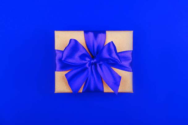 Cardboard gift box with bow on red background. - Fotoğraf, Görsel