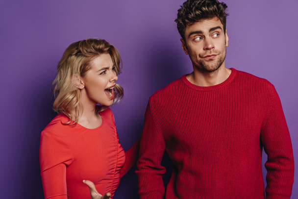 angry girl quarreling with boyfriend looking away on purple background - Foto, immagini
