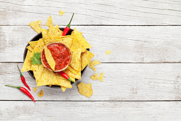 Mexické nachos chipsy se salsou. Horní pohled byt ležel na dřevěném stole s kopírovacím prostorem - Fotografie, Obrázek