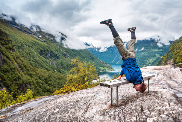 guy doing the trick on the bench over Geiranger fiord - Photo, image