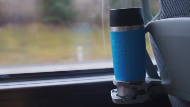 Close-up of a thermo mug of a tourist bus chair standing in a cup holder. - Záběry, video