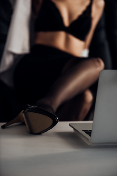 Обрезанный вид привлекательной девушки в чулках и туфли на высоком каблуке позирует перед веб-камеры
 - Фото, изображение