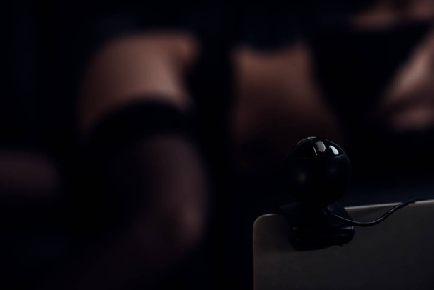 Valikoiva painopiste kannettavan web-kamera ja seksikäs nainen sohvalla
 - Valokuva, kuva