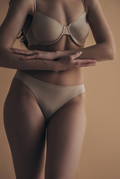 Vista recortada de chica sensual en lencería tocando manos aisladas en beige
 - Foto, imagen