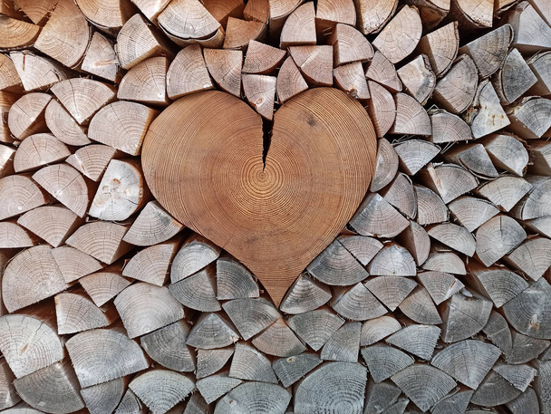 Primer plano del cartel del corazón de madera en un montón de troncos de leña
 - Foto, imagen