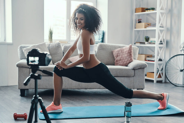 Beautiful young African woman working out and smiling while making social video  - Foto, Imagen
