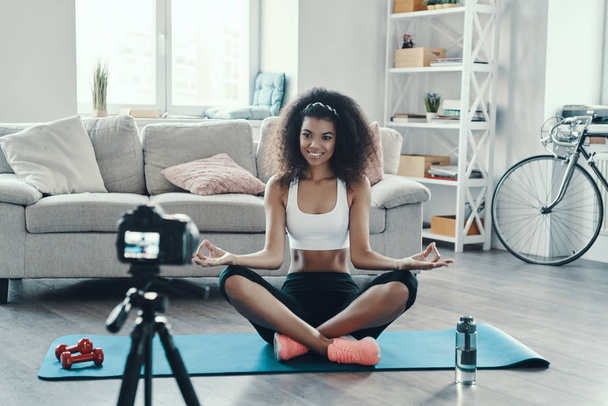 Beautiful young African woman working out and smiling while making social media video - Zdjęcie, obraz